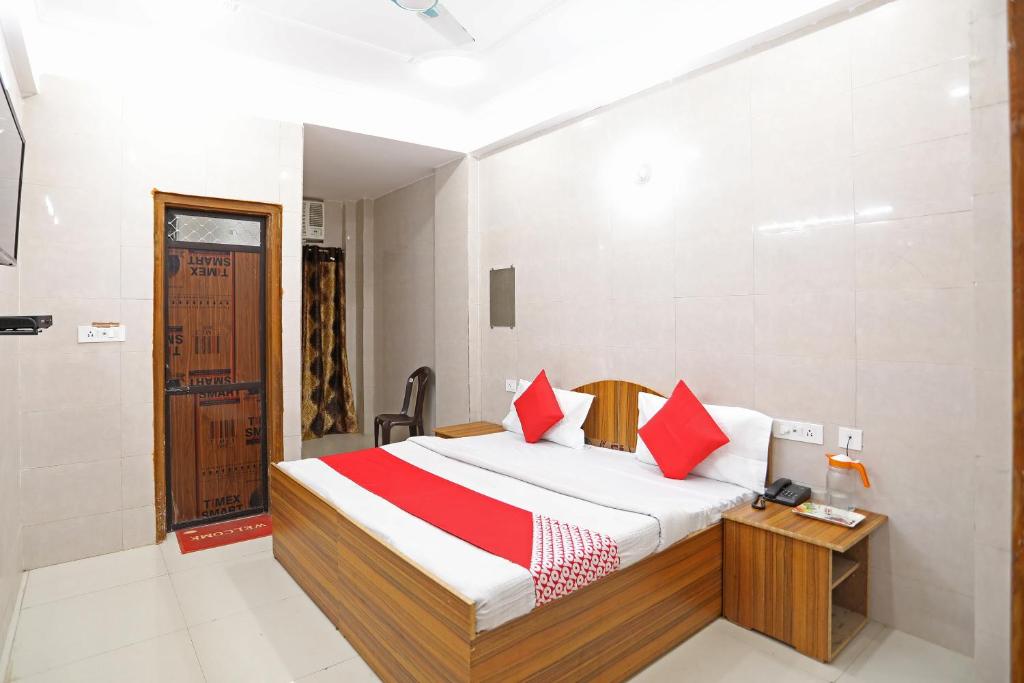 a bedroom with a bed with red pillows at Hotel O Shree Raghuvar Dham in Vrindāvan