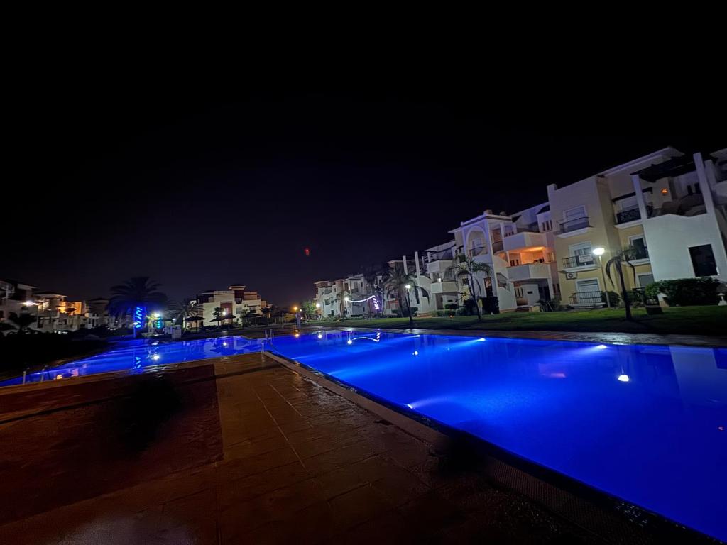 a swimming pool with blue lights at night at Luxueuse à Marina Saidia in Saïdia
