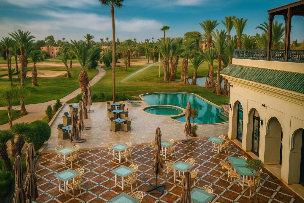 an aerial view of a resort with a pool and palm trees at Palmeraie Golf Suites By Pickalbatros in Marrakech