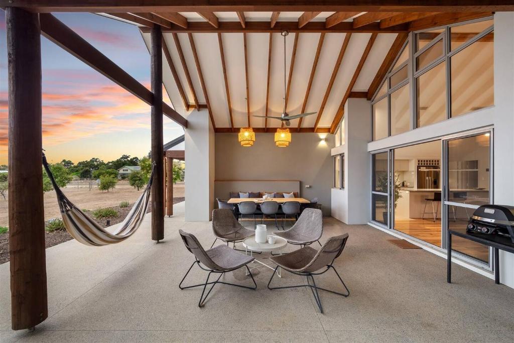 - un salon décloisonné avec une table et des chaises dans l'établissement Amaroo - Luxe Hinterland Three-bedroom Farmhouse with Studio, à Quindalup