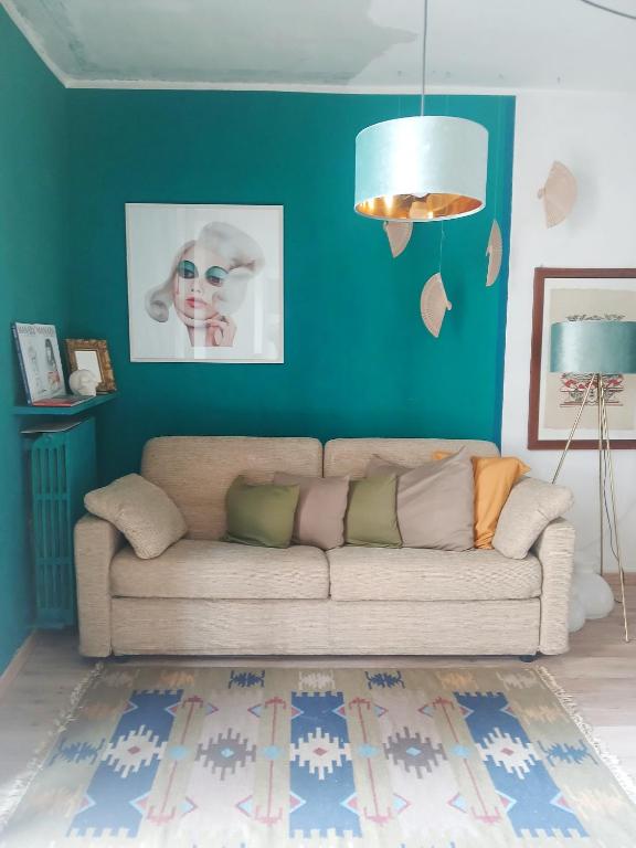 a living room with a couch and a blue wall at RaMaya casa d'artista 2 in Biella