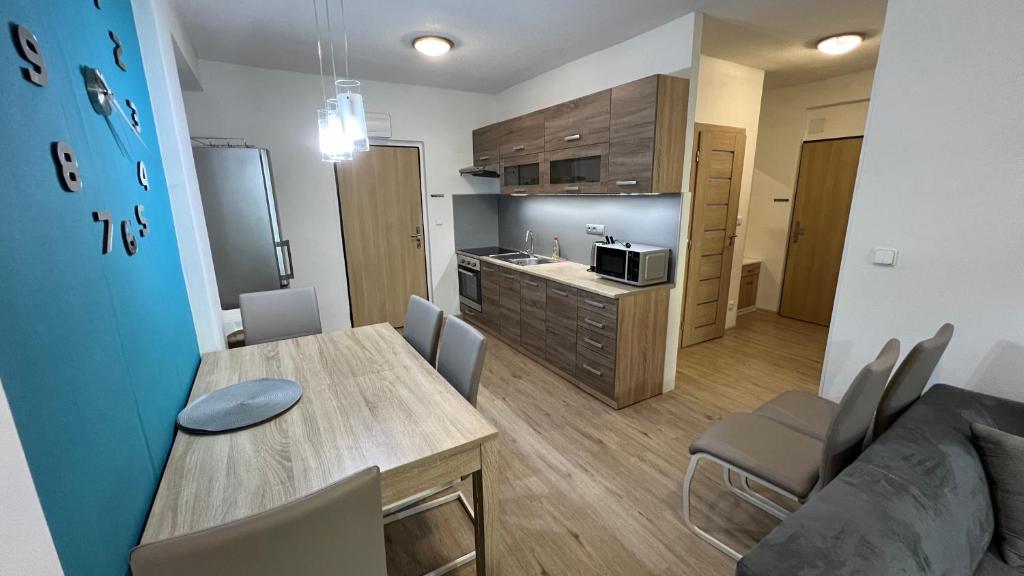 a living room with a dining table and a kitchen at Apartmán Všemina 14A in Všemina