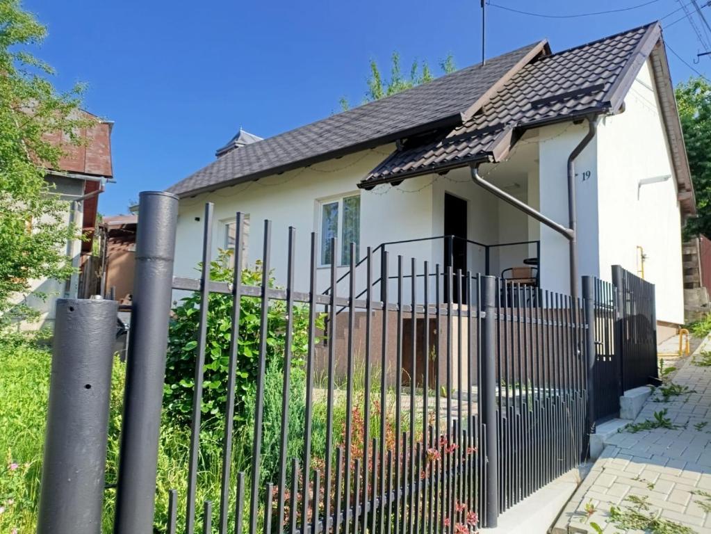 une clôture devant une maison blanche dans l'établissement Căsuța de la Răscruce, à Câmpulung Moldovenesc
