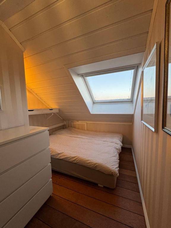 a small bed in a small room with a window at Flott leilighet med fantastisk utsikt in Stavanger