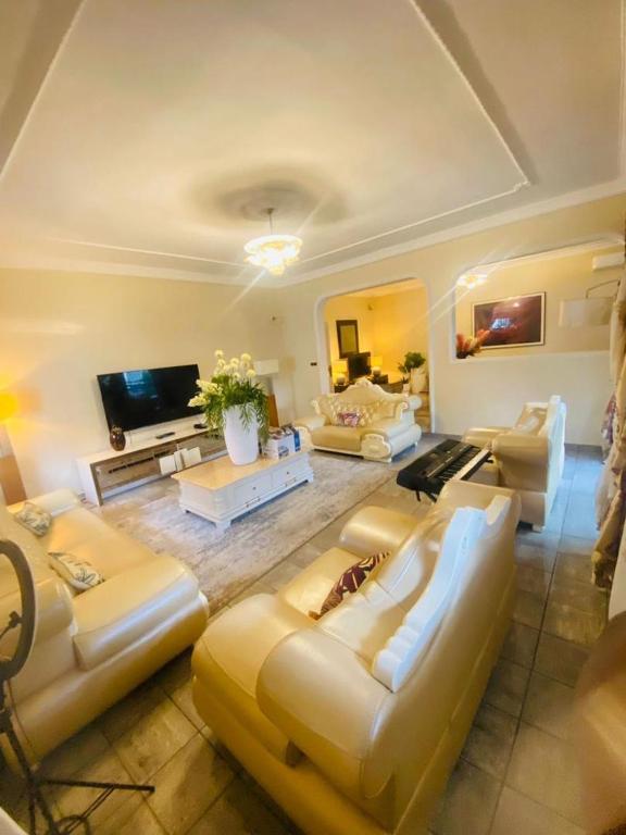 een grote woonkamer met banken en een televisie bij Eldorado palace in Douala