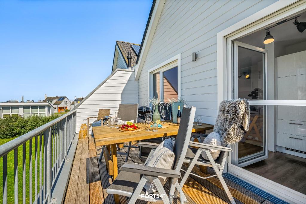 a deck with a wooden table and chairs on a house at Ferienwohnung Nicks Seestern Olpenitz in Olpenitz