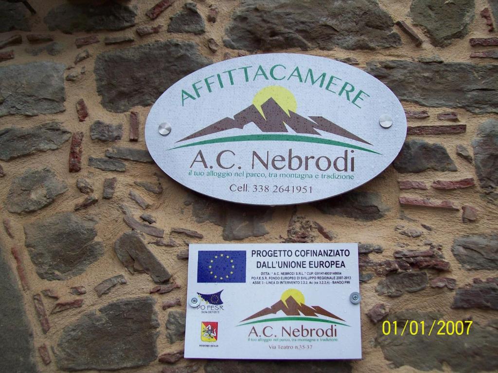 un cartello sul lato di un muro di pietra di Affittacamere Nebrodi a Capizzi