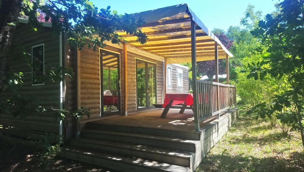 a small cabin with a red chair on the porch at Domaine fontaine du roc in Dévillac