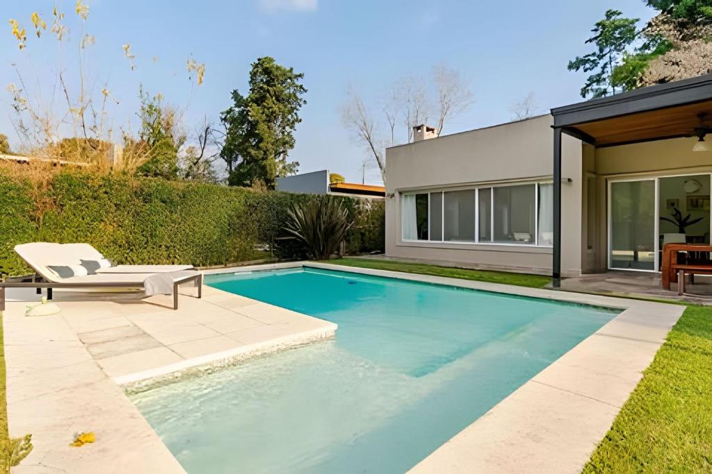 Bazén v ubytování Divina casa con parque y Pileta Climatizada en barrio cerrado nebo v jeho okolí