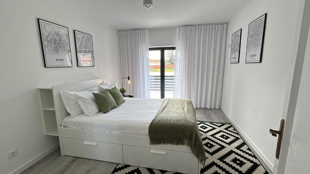 a white bedroom with a bed and a window at Villa Seixo - Spa, Beach and Nature in A dos Cunhados