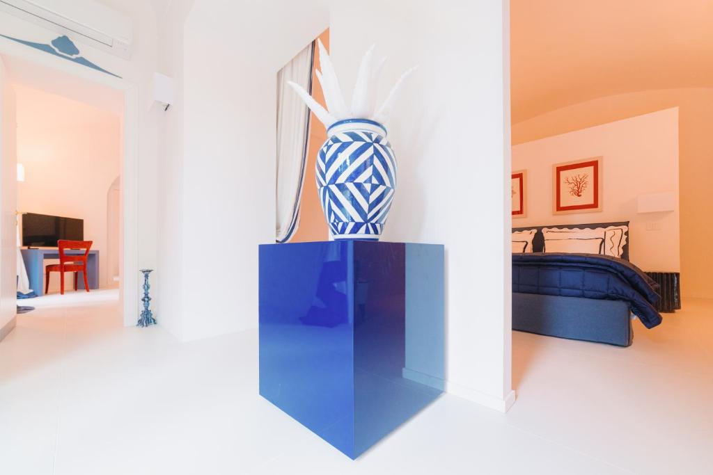 une pièce avec un vase bleu sur un mur dans l'établissement Villa Chiara - Lavi Luxury Apartments, à Capri