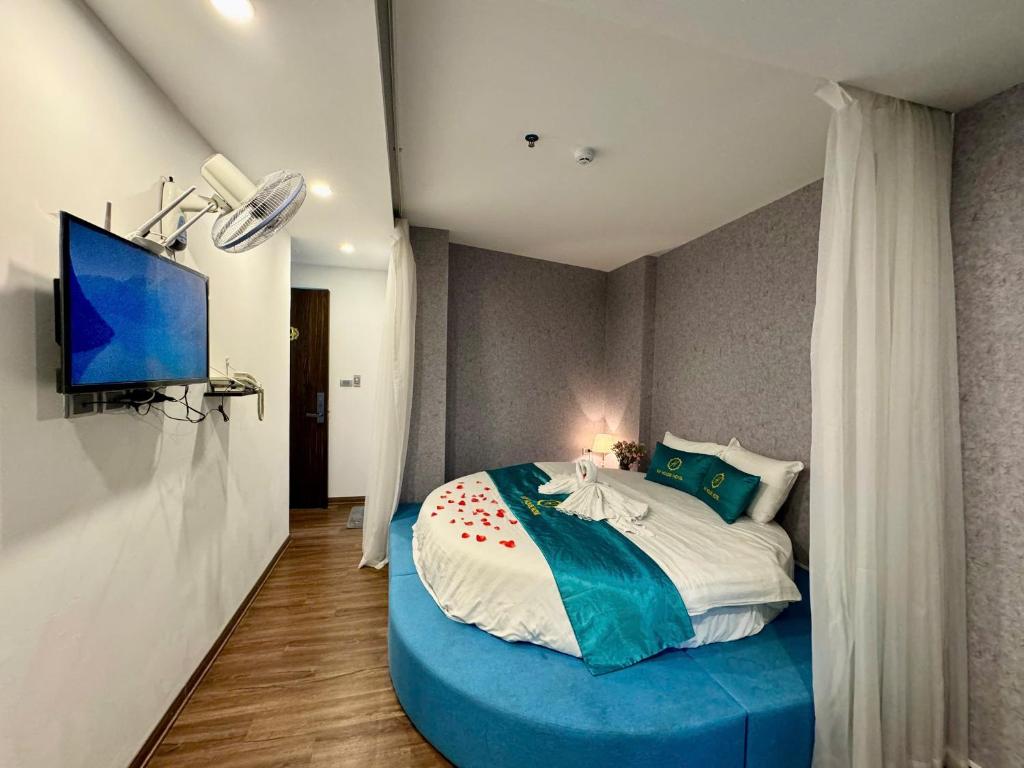 a bedroom with a large bed with a blue bed frame at My House Hotel Hanoi in Hanoi