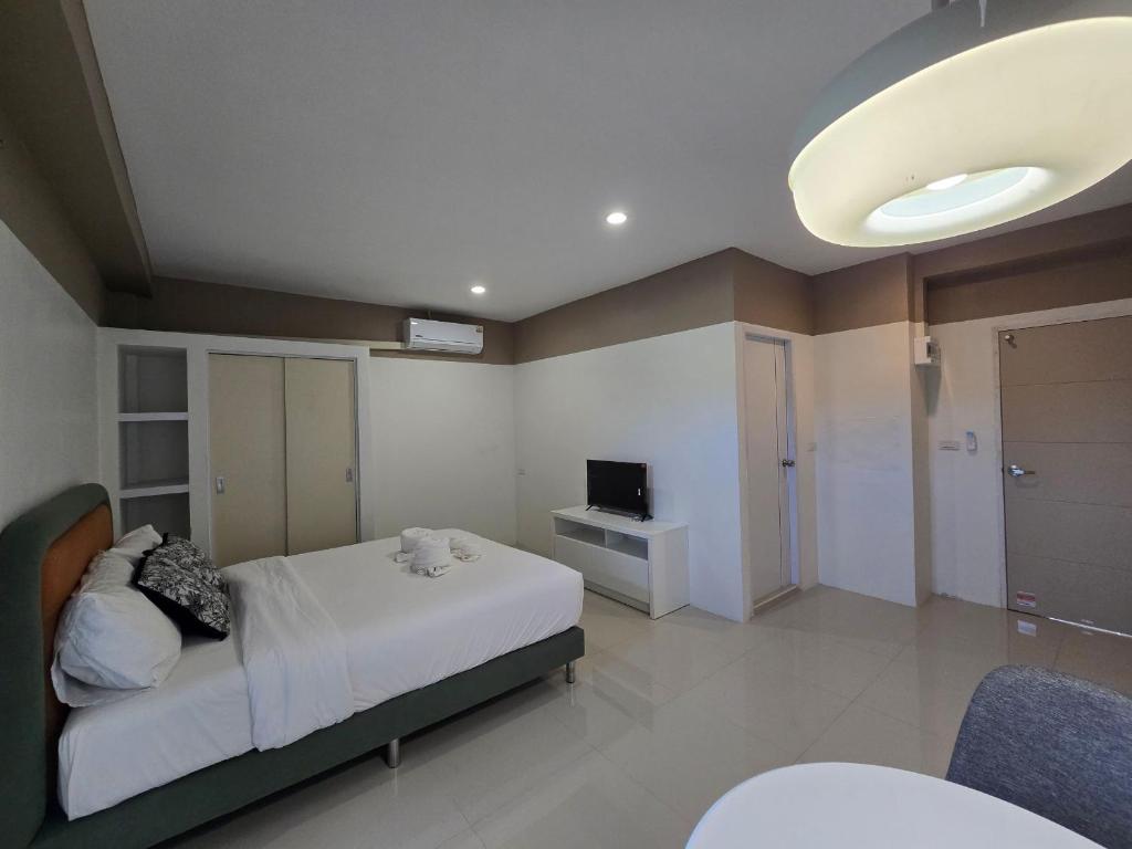 a bedroom with a bed and a television in it at Hommory Residence - Phuket Town in Ban Lo Long