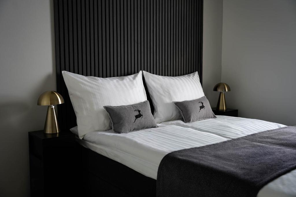 ein Schlafzimmer mit einem Bett mit weißen Laken und Kissen in der Unterkunft Premium Apartment With Sauna & Parking - Lapnest in Rovaniemi