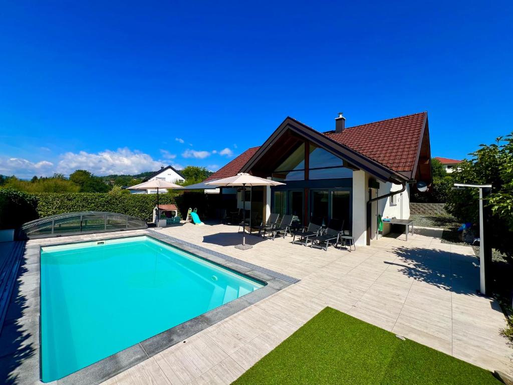 a swimming pool in front of a house at Modernes Ferienhaus mit Pool Nähe Wörthersee & Golfplatz in Feldkirchen in Kärnten