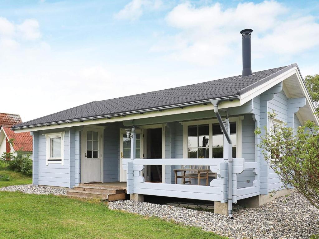 a small white house with a white porch at 6 person holiday home in Roslev-By Traum in Flovtrup