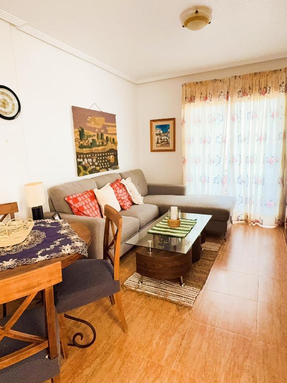a living room with a couch and a table at Costa Oasis Residencia La Mirada in Orihuela Costa