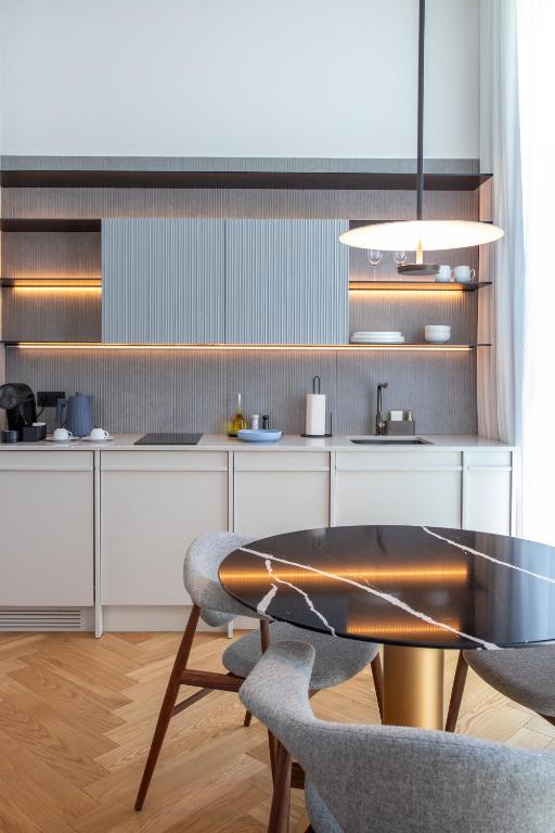 A compact kitchen and dining corner with integrated appliances and open shelving.