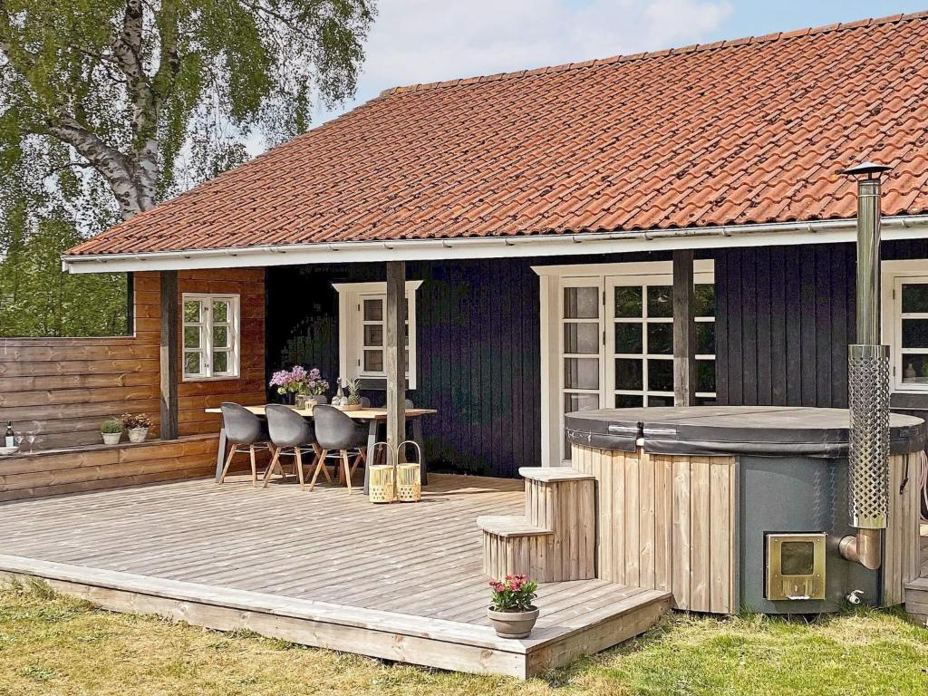 グレーノにある7 person holiday home in Grenaaのデッキ(テーブル、椅子付)が備わる家