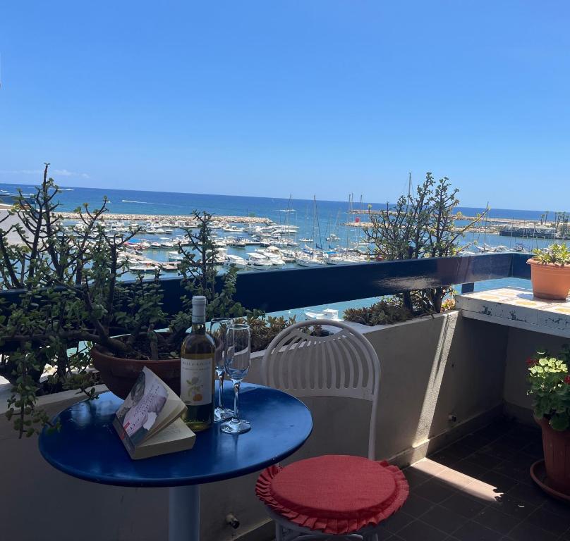 a table with a bottle of wine and glasses on a balcony at Bed Cafè in Siracusa