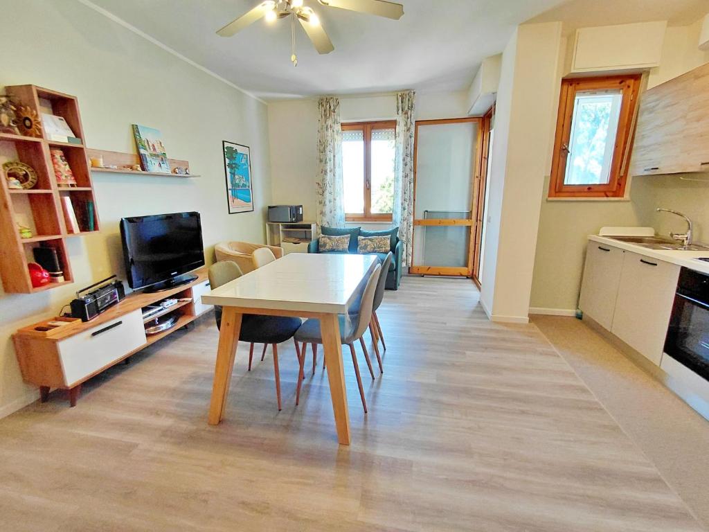 a living room with a dining room table and a kitchen at Appartamento a due passi da Maria Pia in Alghero