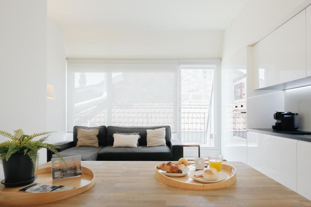 a living room with a couch and a table with food on it at Galerias Nightlife Fashion Flats in Porto