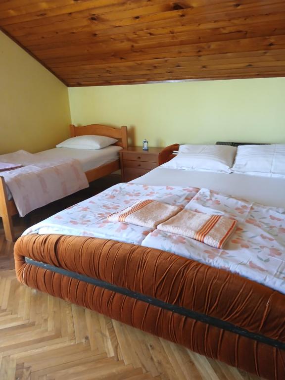 Un dormitorio con dos camas y techo de madera. en HOSTEL BATA APARTMANI, en Kanjiža