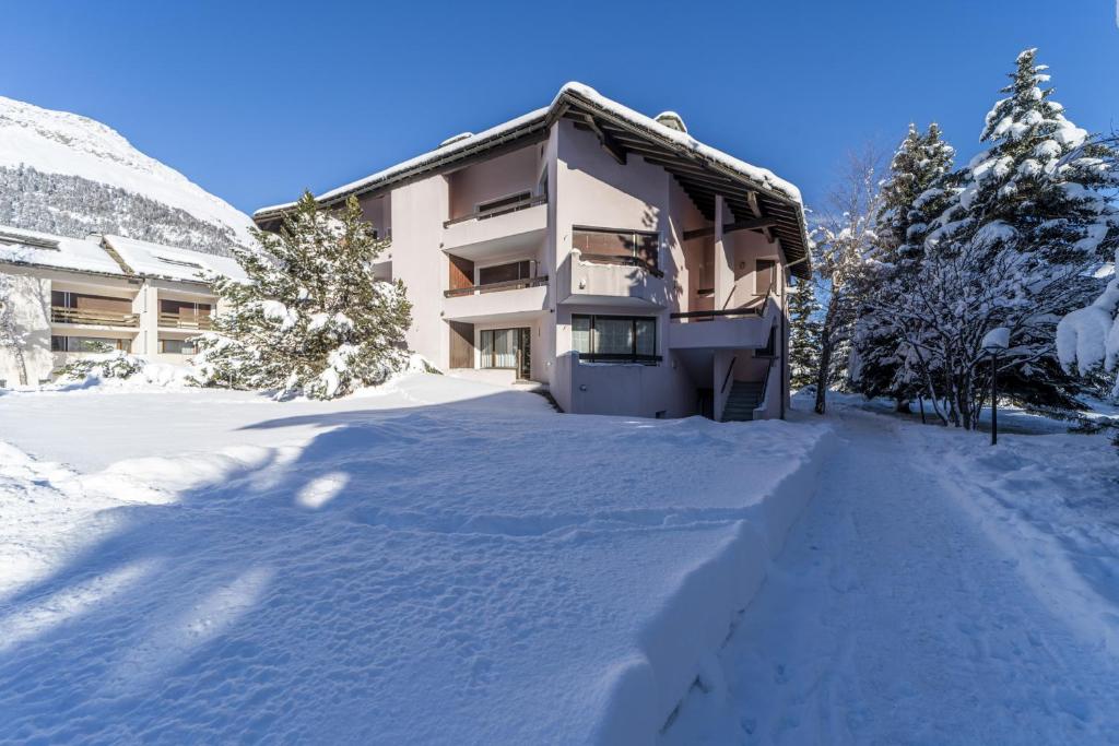 a building in the snow with a snow covered driveway at Chesa Pradatsch Suot 5 - Celerina in Celerina