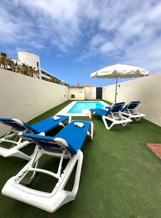 a group of chairs and an umbrella and a pool at DUPLEX C6 con PISCINA PRIVADA in Callao Salvaje