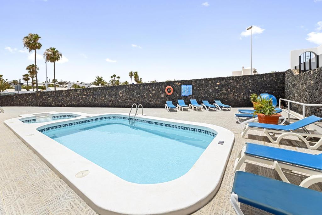 una piscina con tumbonas y una piscina en Paraiso Marino by EscapeHome, en Los Pocillos