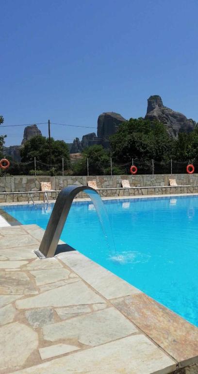 a swimming pool with a water fountain in it at Farmhouse Meteora Garden in Kastraki