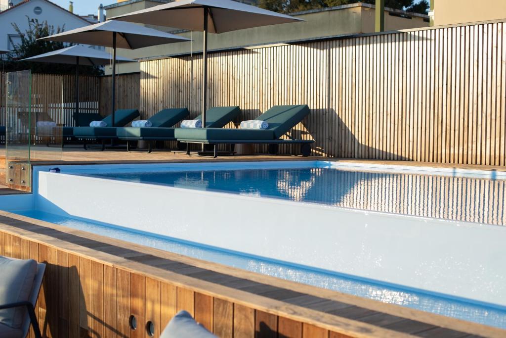 A rooftop-style swimming pool with loungers and umbrellas.