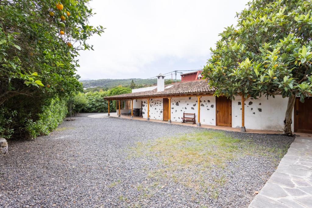 an exterior view of a house with a gravel driveway at Casa Rural El Naranjero in Tanque