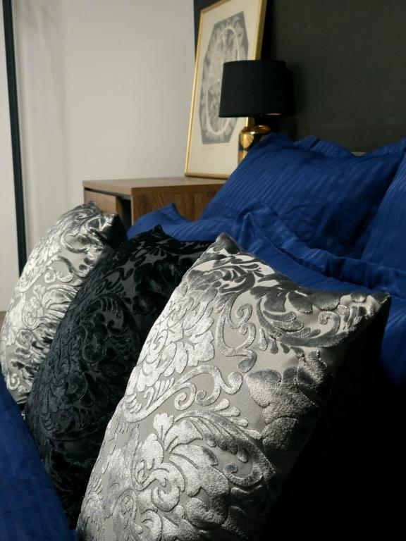 a bed with a black and white comforter and pillows at GLAMOUR Style Apartment in Cluj-Napoca
