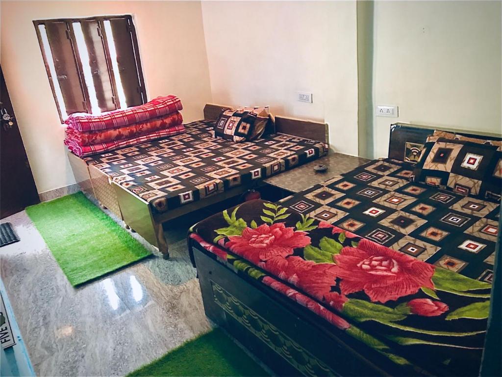 two beds sitting in a room with green carpet at Devdarshan Hotel & Tourist Guest House Sonprayag in Jāmb