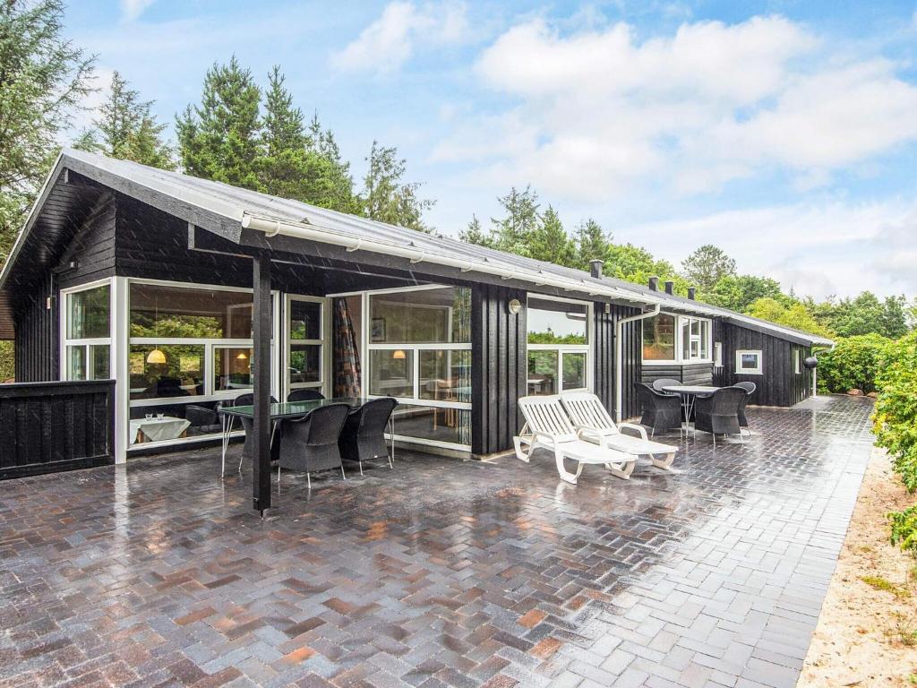 a house with a black roof and a patio at 7 person holiday home in Henne-By Traum in Henne Strand