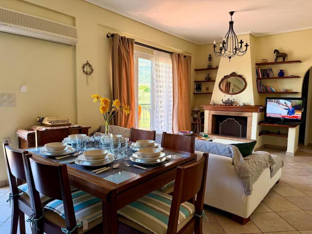 een eetkamer met een tafel en een bank bij Trizonia View Beach House - Glyfada Village by MPS in Glyfada Fokidas