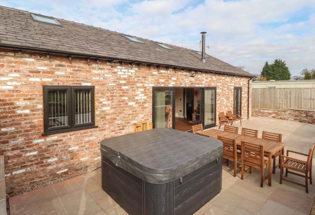 a patio with a table and chairs and a brick building at The Parlour in Helsby