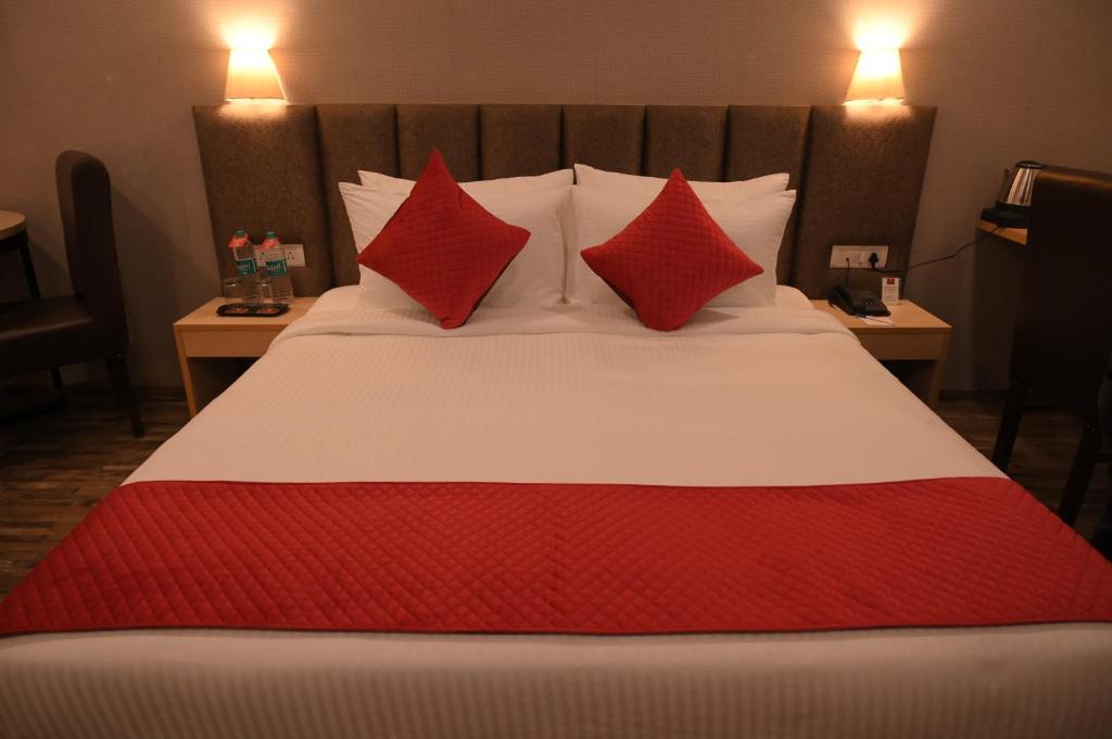a bed with two red pillows on top of it at Ayaan Residency in Noida