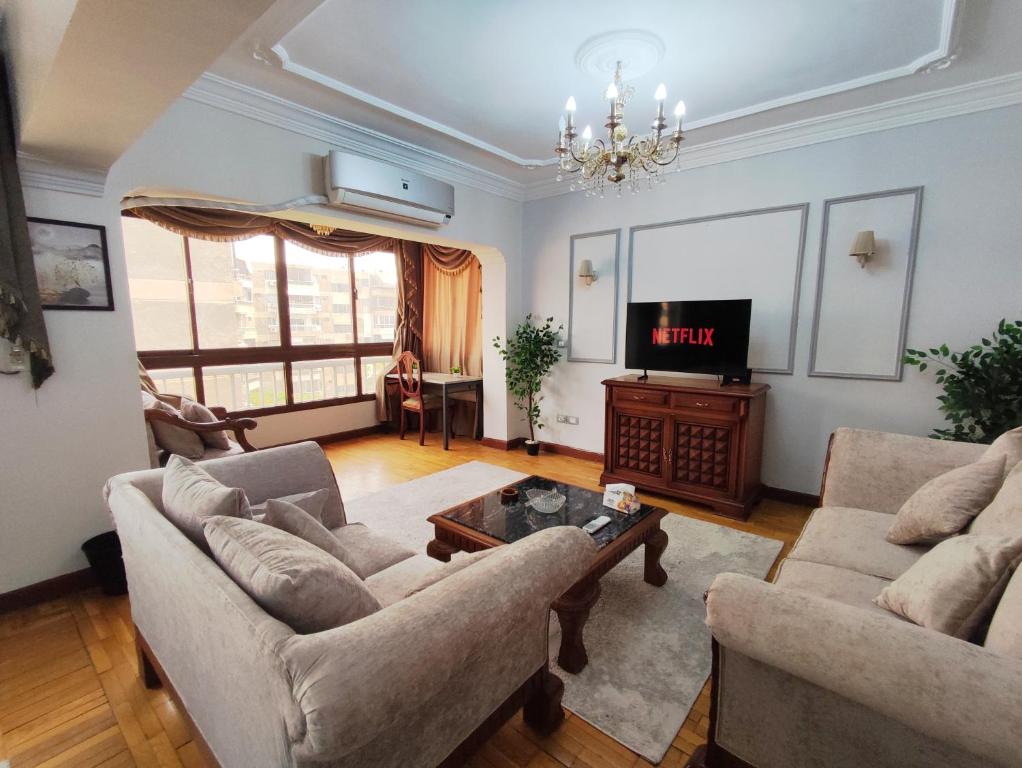 a living room with two couches and a tv at Where landsacpe view meets Luxury in Cairo