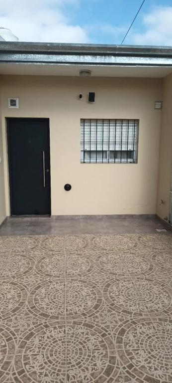 a building with a black door and a tile floor at Las Costas - Tu descanso in Cañuelas