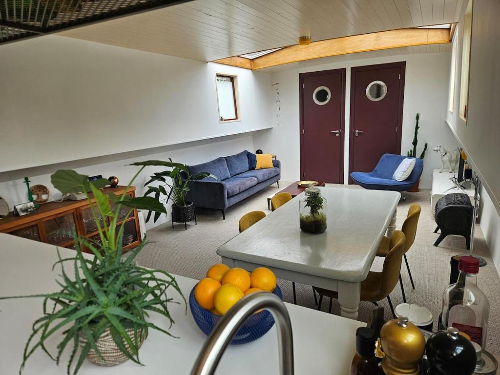 a kitchen and a living room with a table at Woonboot - Houseboat Amsterdam in Amsterdam