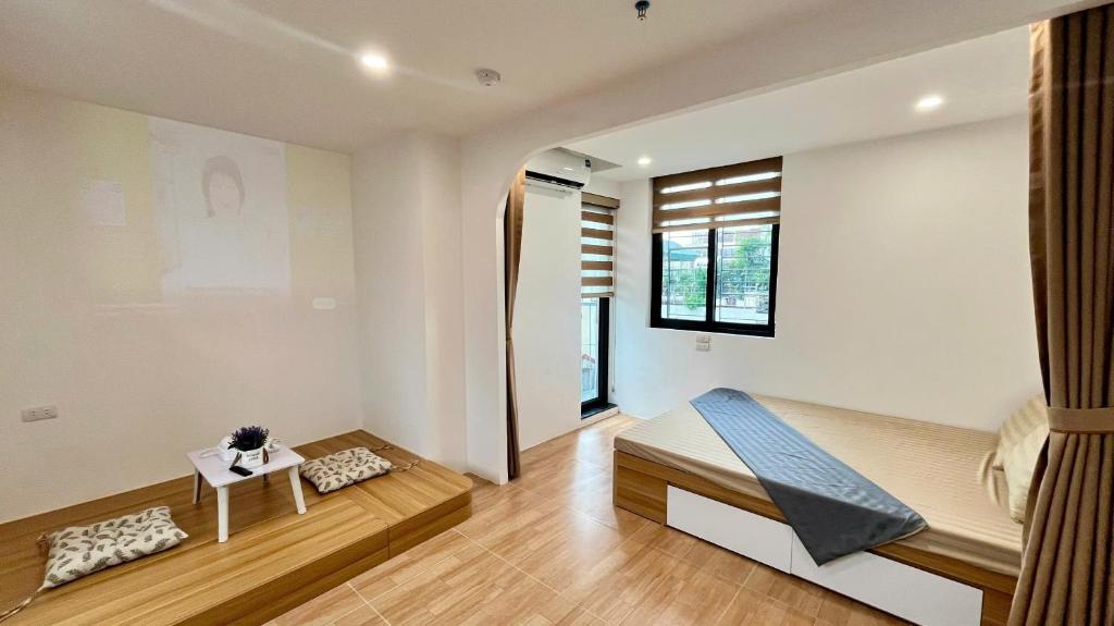a bedroom with a bed and a table at Era Apartment Tam Da in Hanoi
