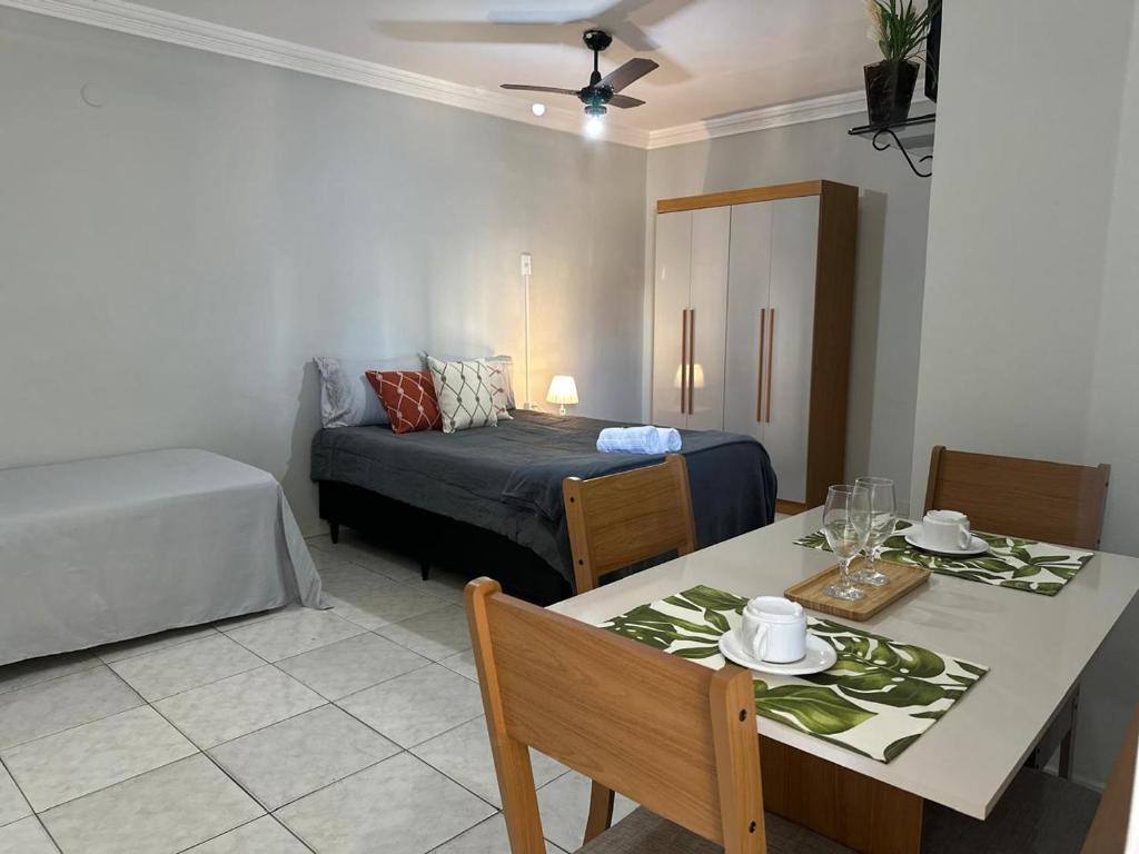 カンポス・ドス・ゴイタカゼスにあるÓtimo Apartamento Aconcheganteのリビングルーム(テーブル、ベッド付)、ベッドルーム1室が備わります。