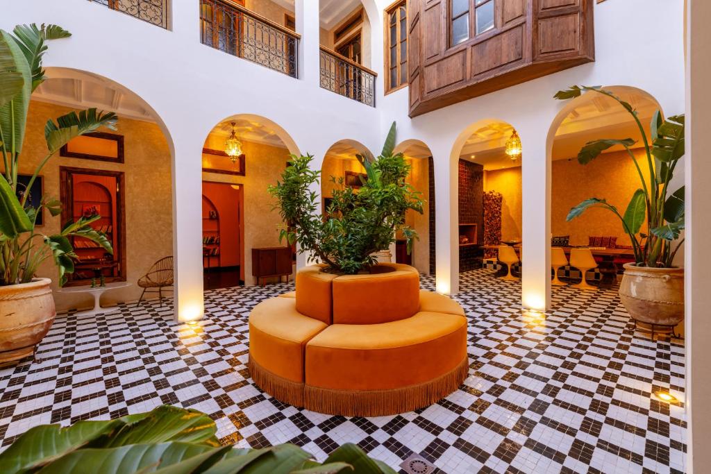 een lobby met een tafel met planten erin bij The Mellah Hotel in Marrakesh