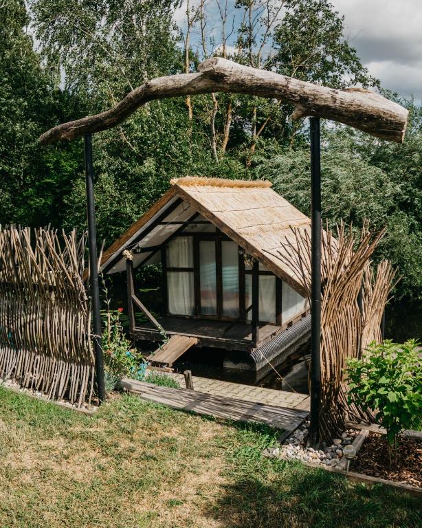 a small cabin with a wooden porch and a fence at Camping Zanzibāra in Ķekava
