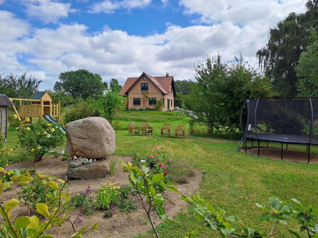 a garden with a house and a ping pong table at Naturhof-Goldbeck in Klütz