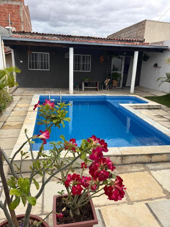 a house with a swimming pool and a plant with flowers at Casa do sossego in Juazeiro do Norte