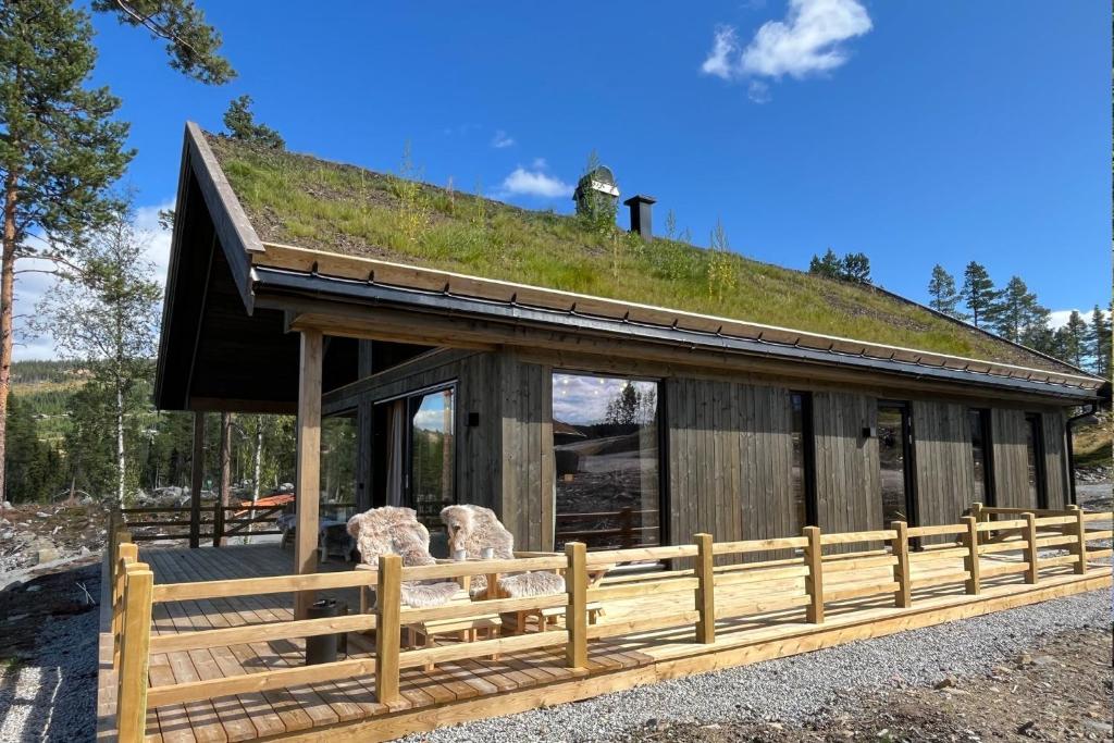 ein Gebäude mit einem Grasdach mit einem Zaun in der Unterkunft Skogsbu - Stylish, Close to Ski centers and hiking trails in Nystølen