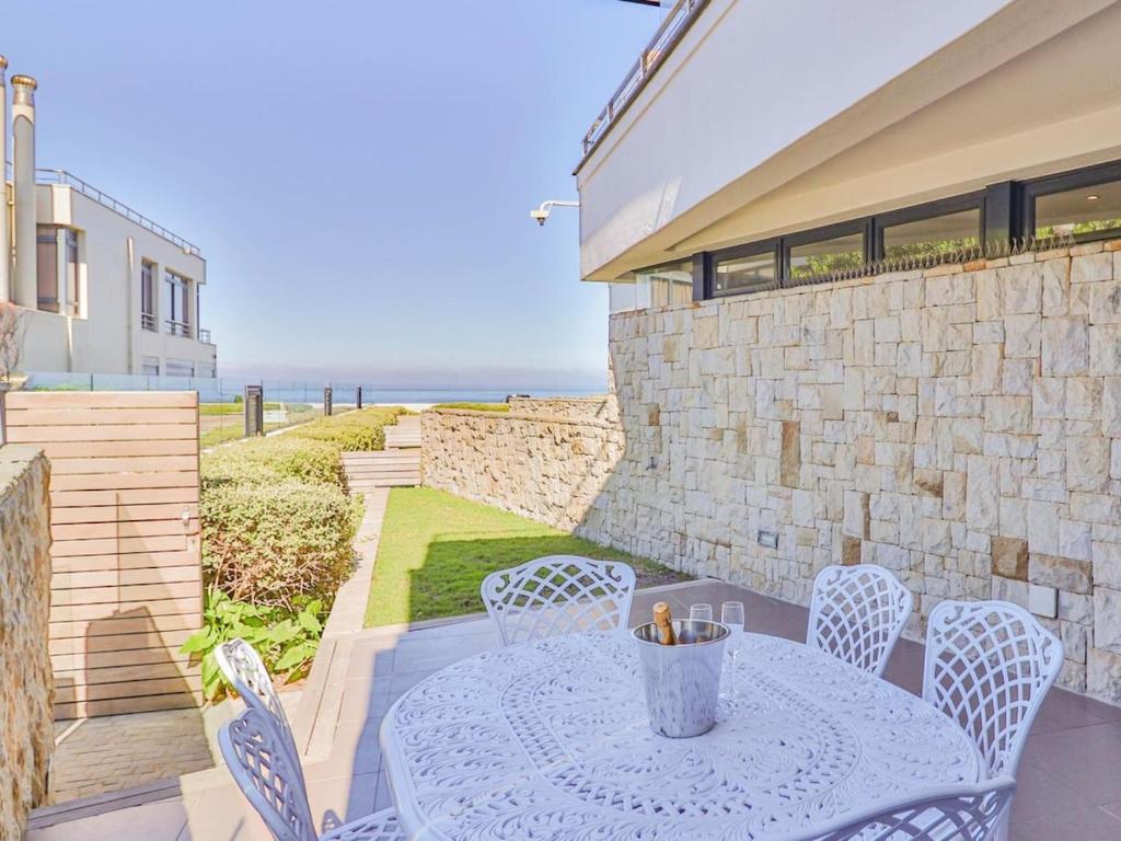 a patio with a table and chairs and the ocean at Le Paradis 5 in Hermanus